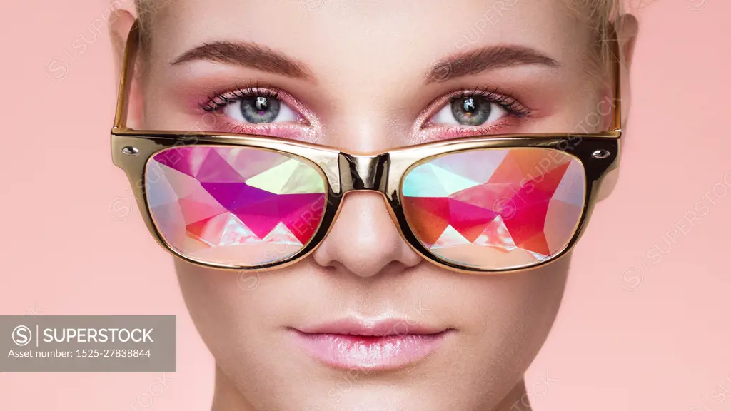Portrait of Beautiful young Woman with Colored Glasses. Beauty Fashion. Perfect Make-up. Colorful Decoration. Holographic sunglasses. Coral color