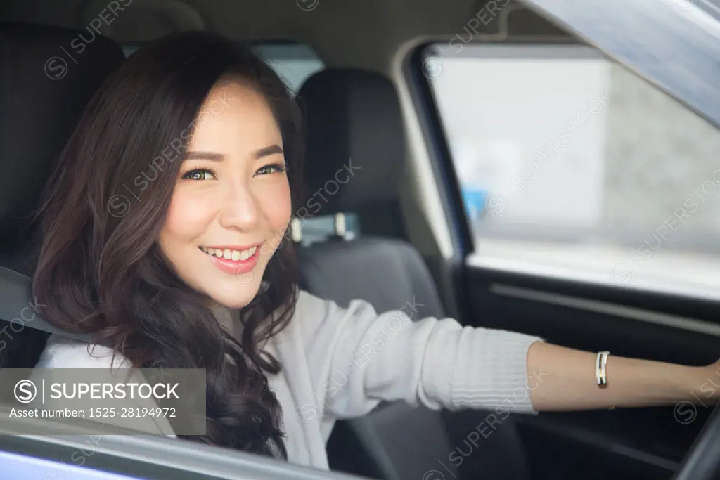 Asian women driving a car and smile happily with glad positive expression during the drive to travel journey, People enjoy laughing transport and relaxed happy woman on roadtrip vacation concept