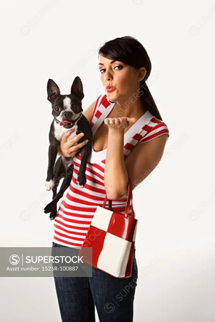 Young adult female Caucasian holding Boston Terrier.