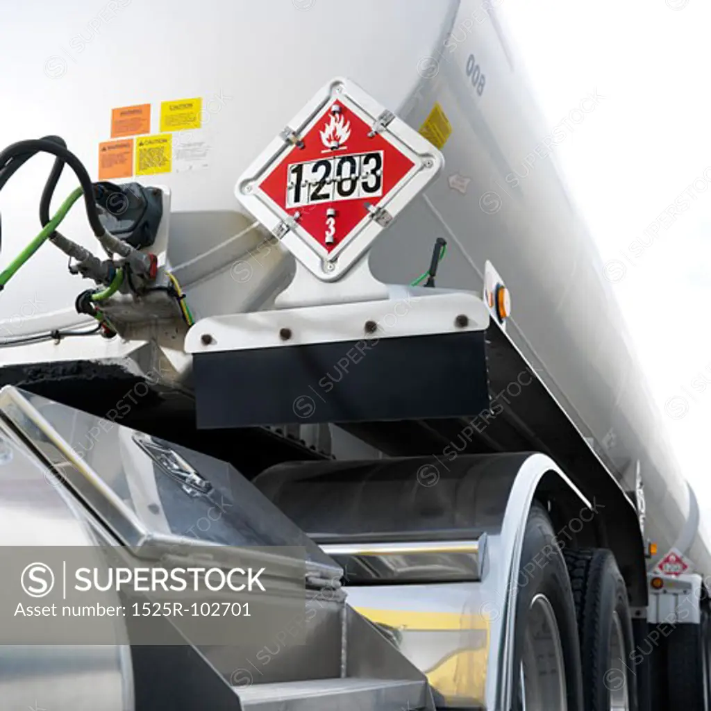 Fuel tank truck with flammable warning sign on back.