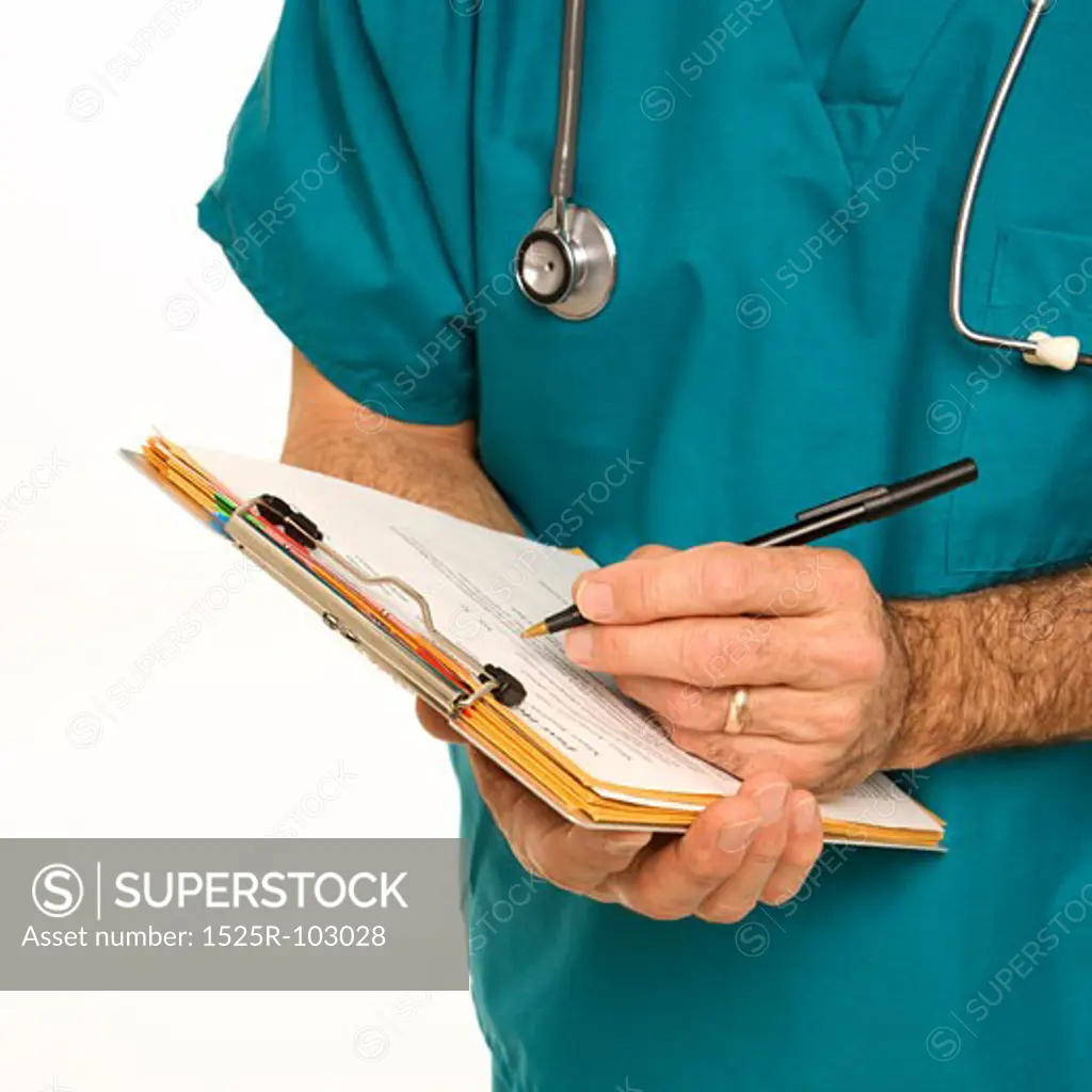 Mid-adult Caucasian male doctor in scrubs making notes on a patient's chart.