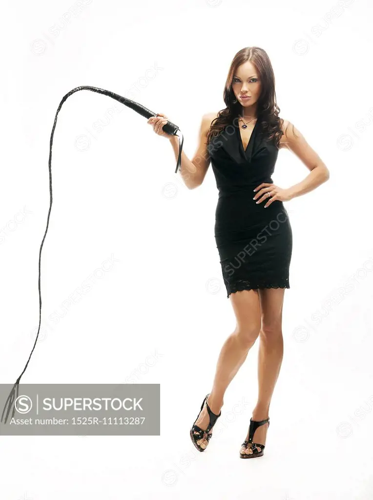 Dominant sexy lady holding a whip, isolated on white