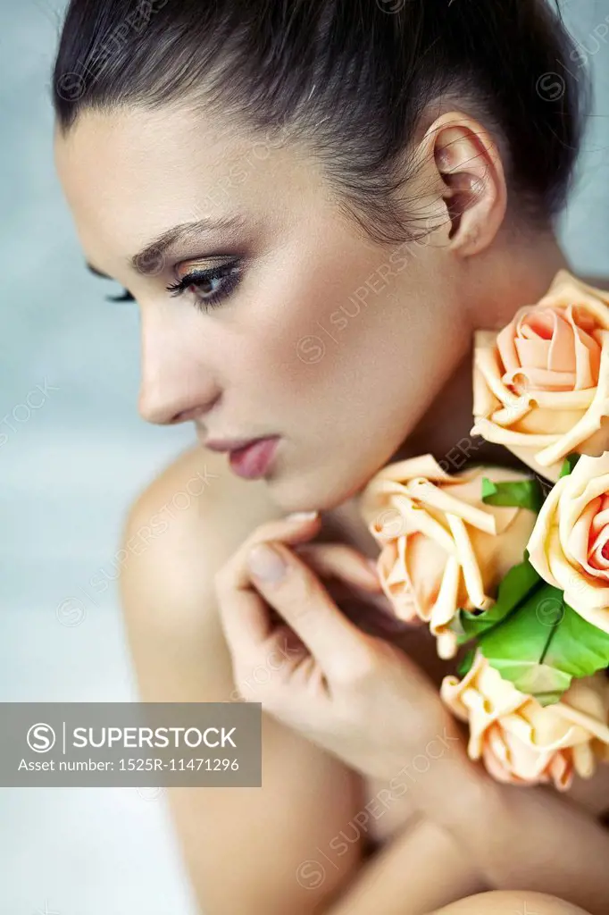 Young lady keeping bouquet of roses