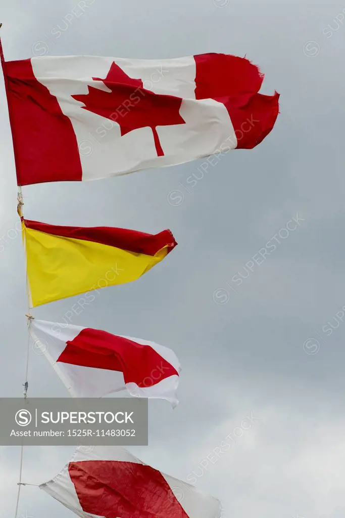 Low angle view of fluttering flags at Lobster Cove Head Lighthouse, Gros Morne National Park, Newfoundland And Labrador, Canada