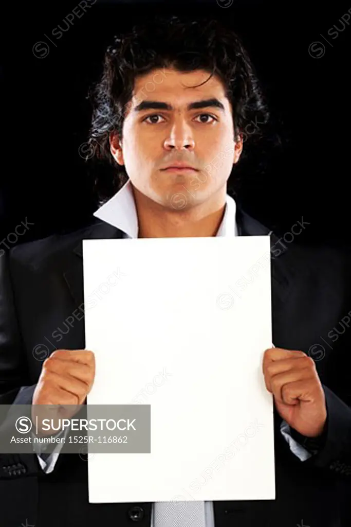 business man displaying a white sheet of paper over a black background