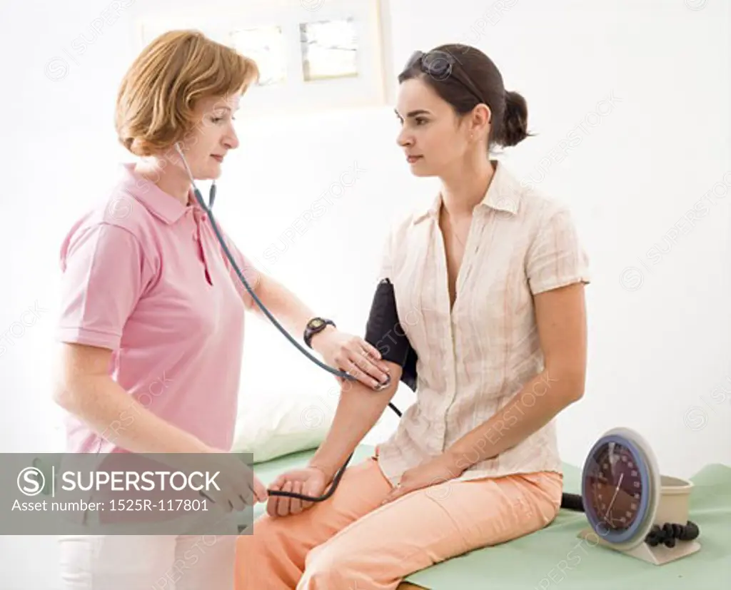 Nurse measuring the patient's blood-pressure.