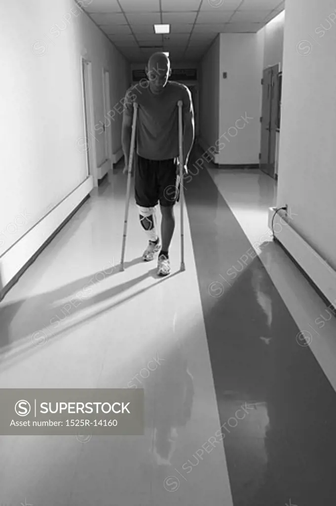 Patient walking down hallway on crutches