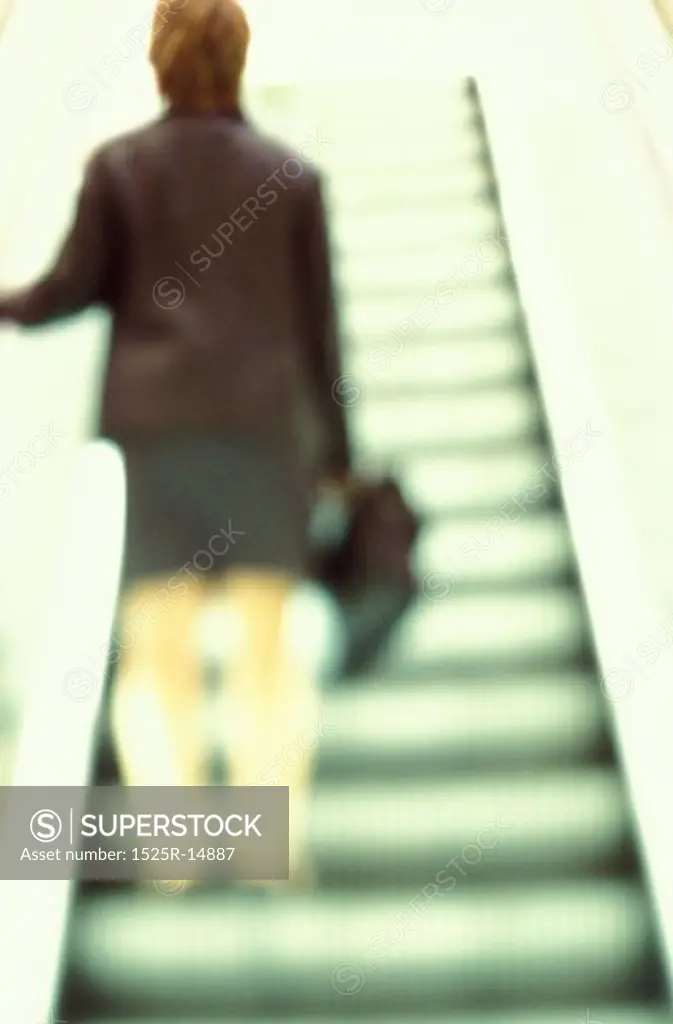 Woman Riding Up Escalator