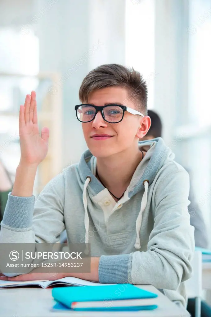 High School students. Student raising his hand in university