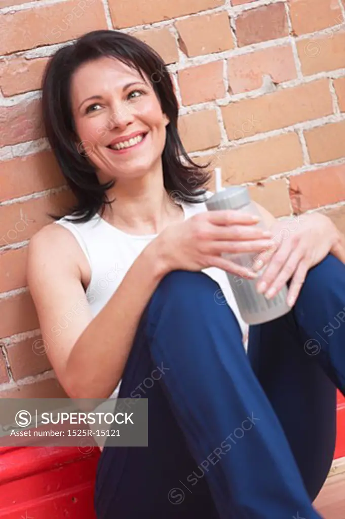 Mature adult woman smiling with water bottle 