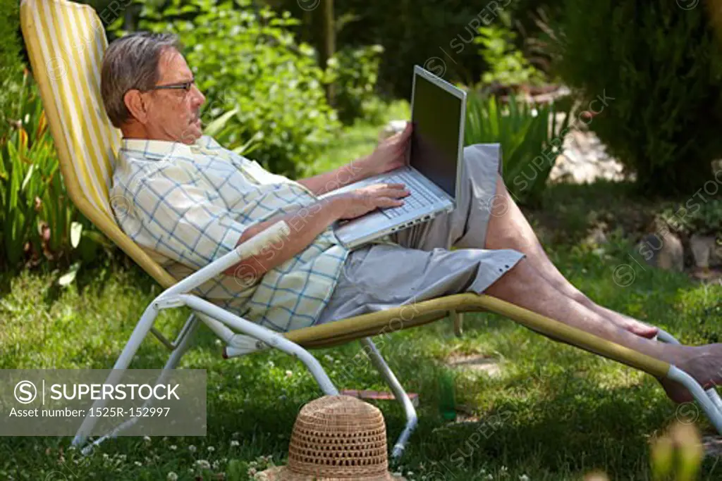 Senior man using laptop outdoor