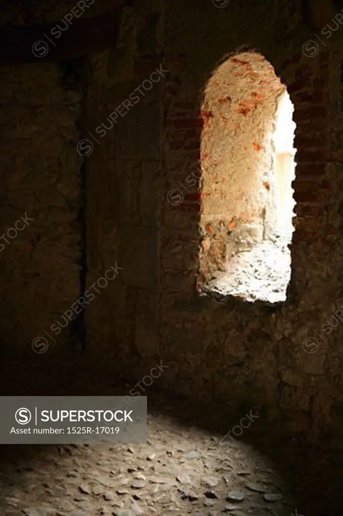 Arched window on interior of stone wall 