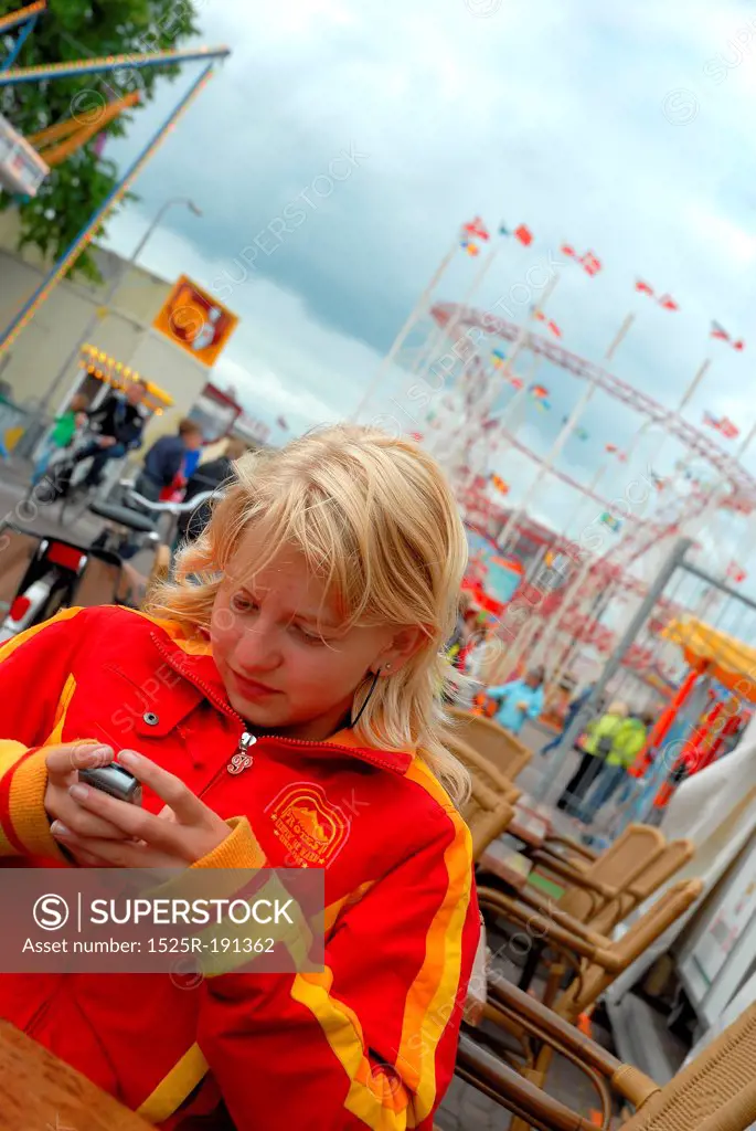 Teenage girl texting from mobile at fairground