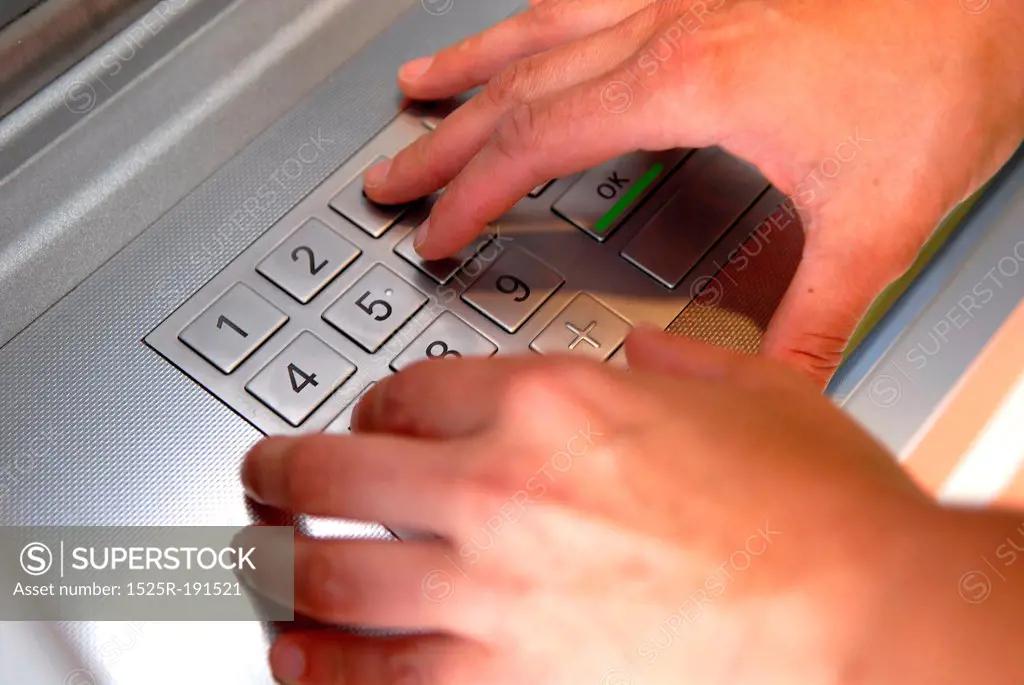 Woman inputting pin into atm machine