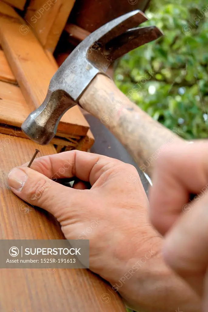 Man hammering nail into wood