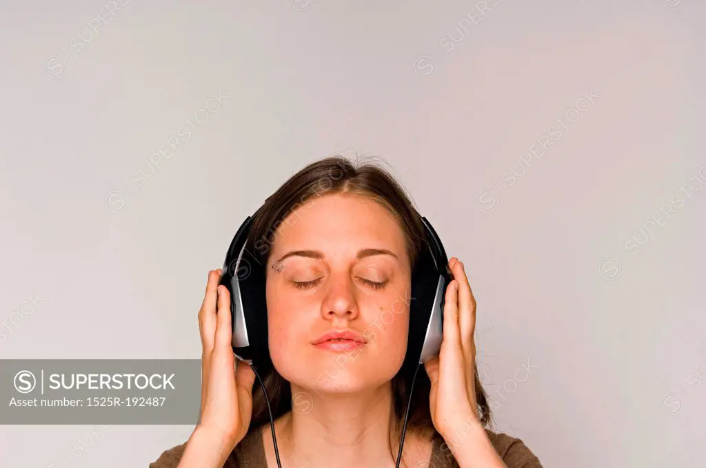 Young woman intently listening to music on headphones.