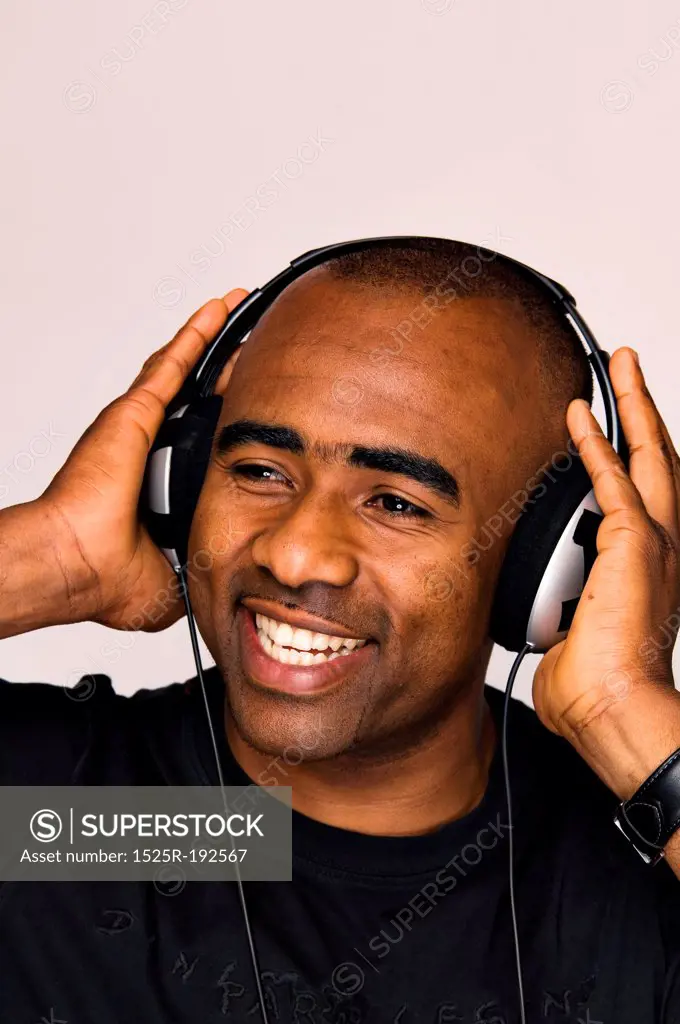 African-American man listening to music on headphones.