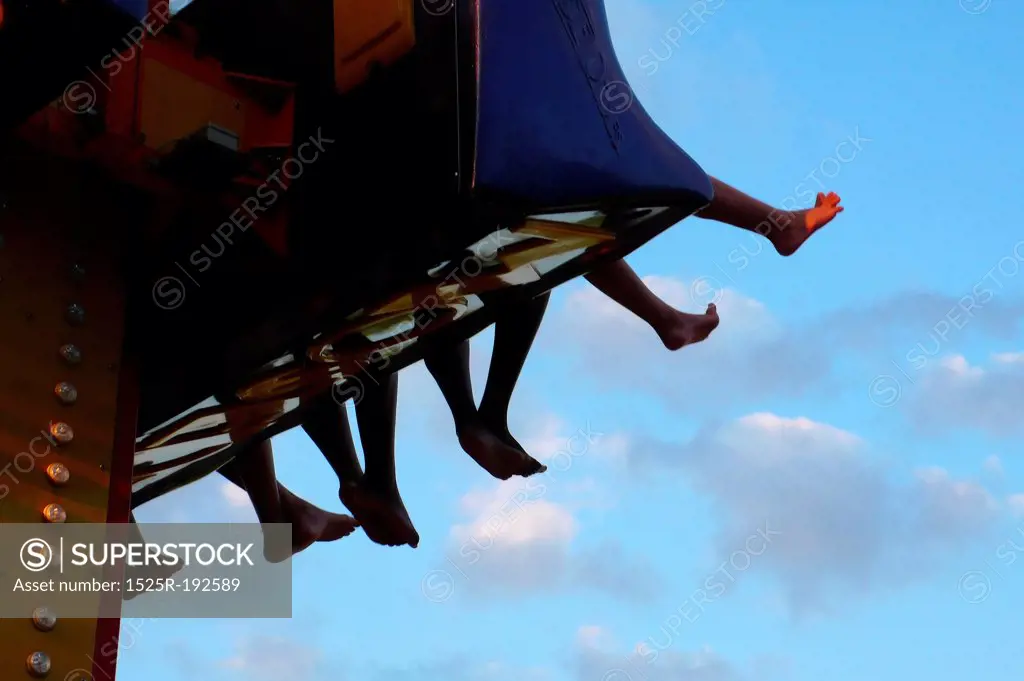 Bare-feet dangling from kid's amusement park ride.