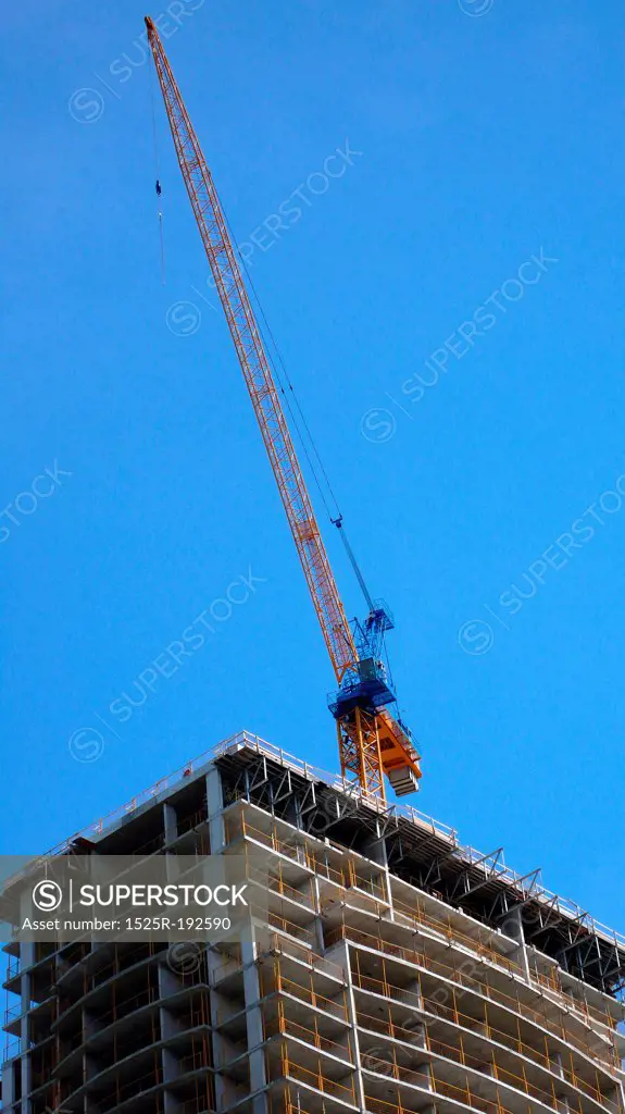 Crane working on partly-constructed building.