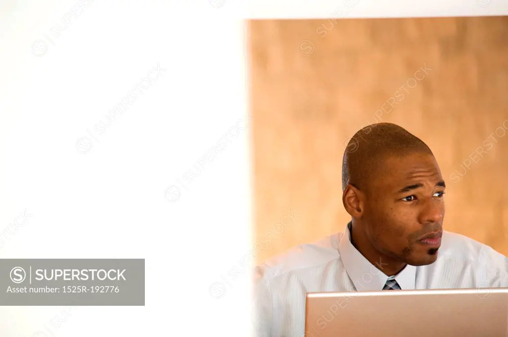 African- American businessman working on laptop.