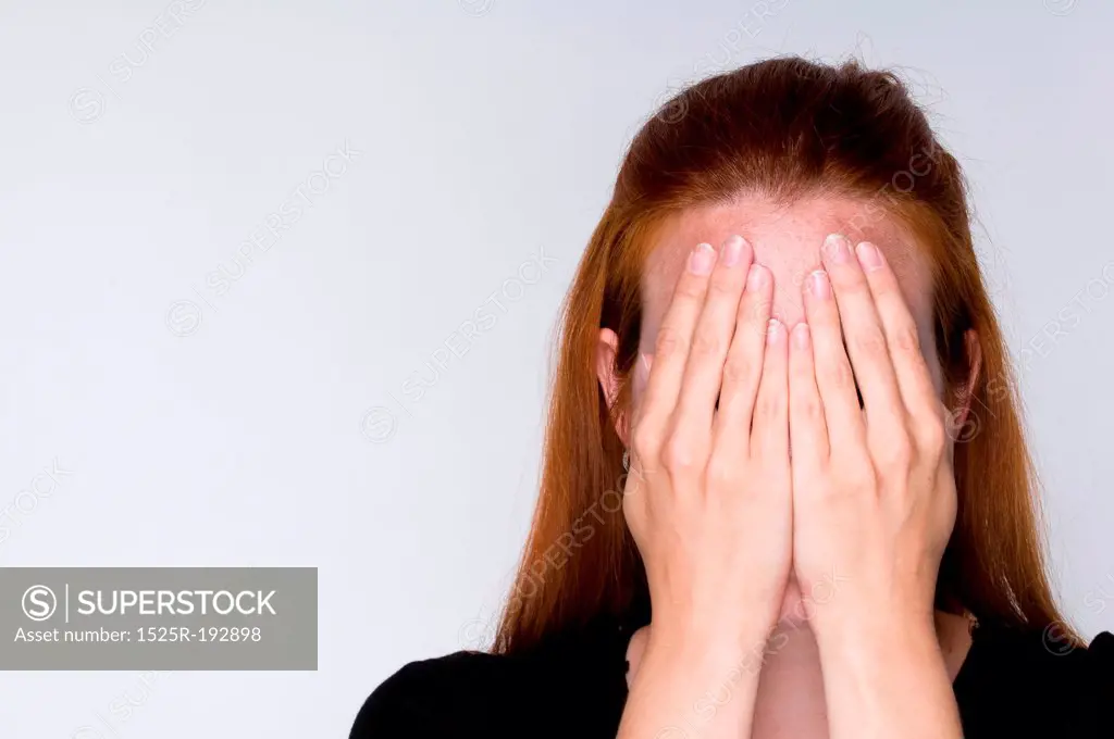 Woman covering face with hands.