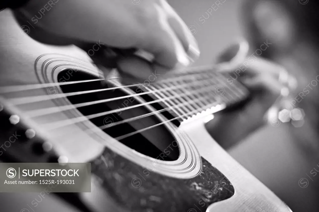 Close-up of acoustic guitar playing.