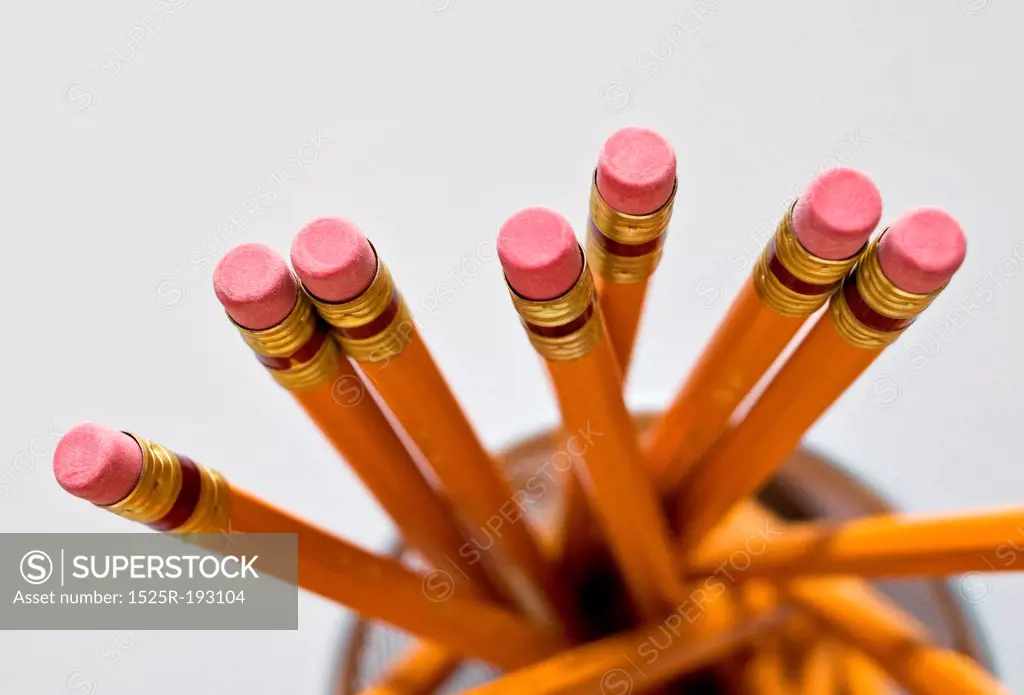 Aerial view of new orange HB pencils in holder, on white background.
