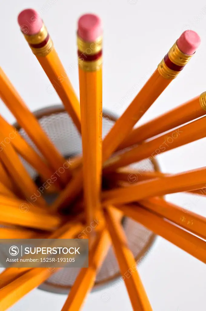 Aerial view of new orange HB pencils in holder, on white background.