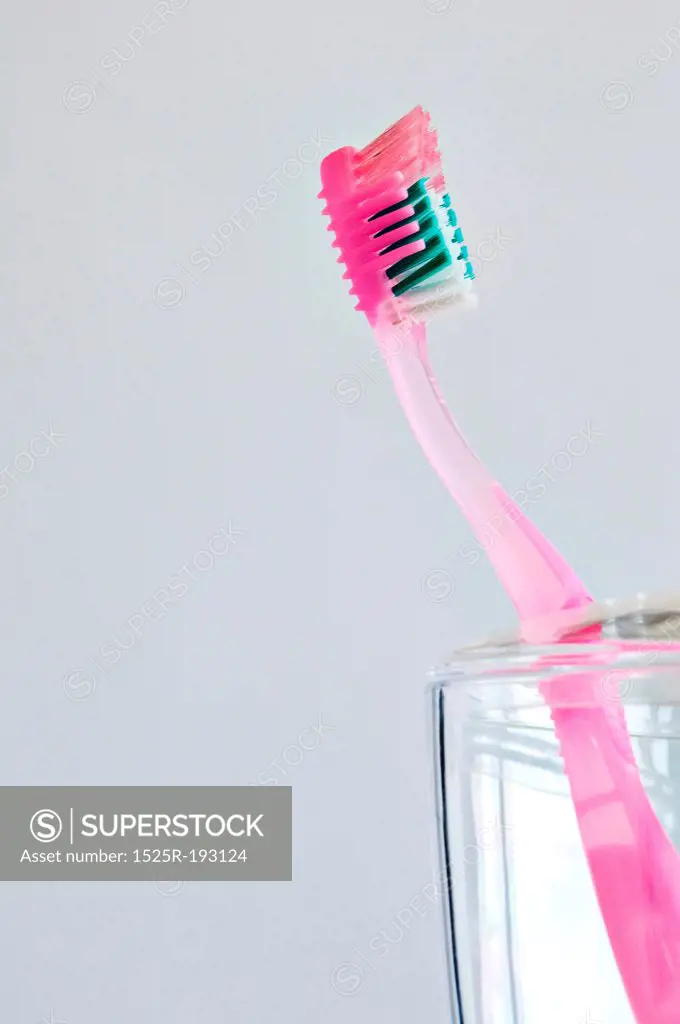 Single pink toothbrush in bathroom toothbrush holder.