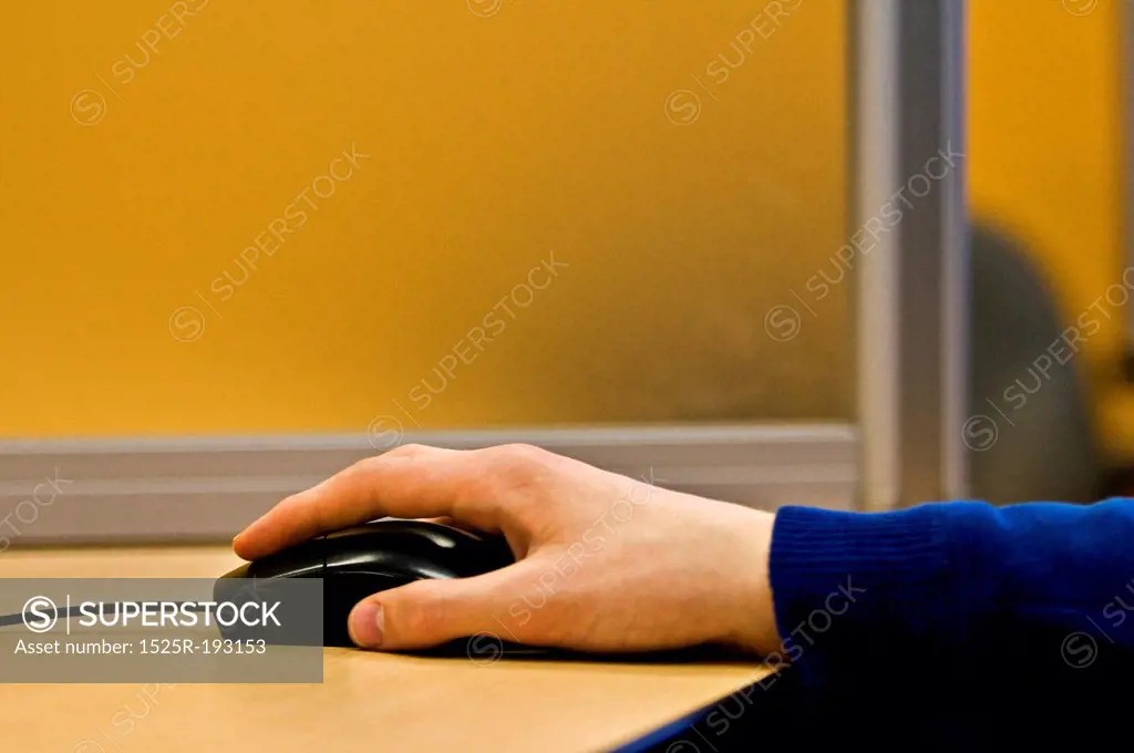 Man's hand on a computer mouse.