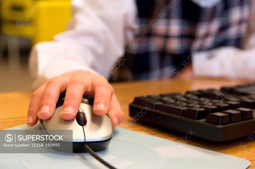 Child's hand on a computer mouse.