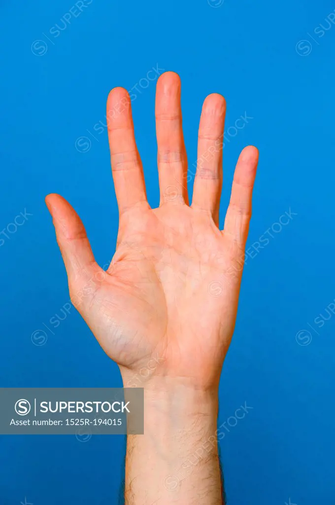 Palm of outstretched hand on blue background.