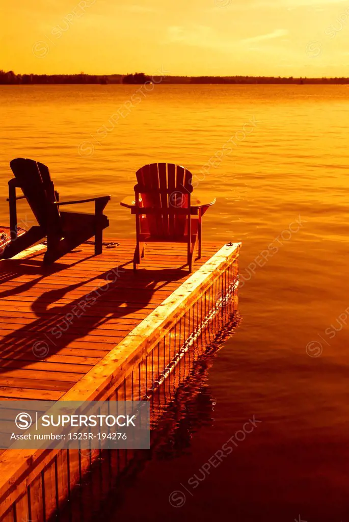 Two Muskoka chairs on dock.