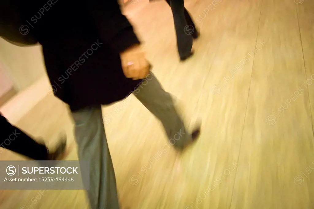 Business people walking quickly indoors.