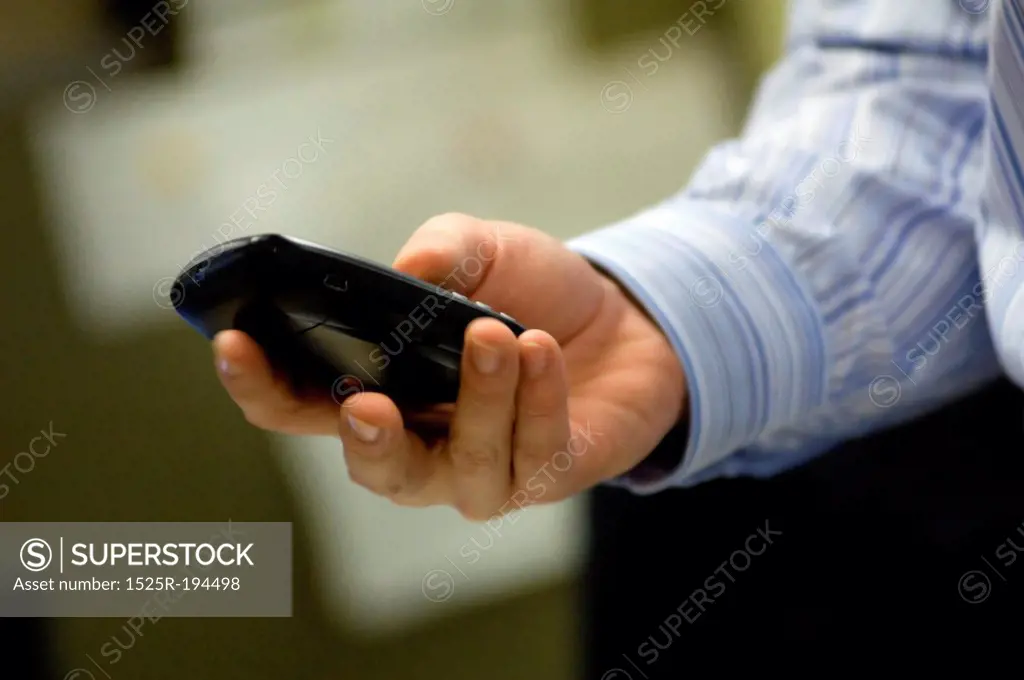 Businessman using PDA while in office.