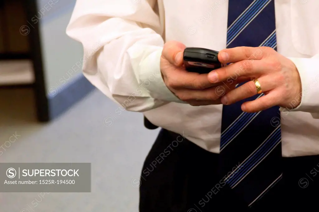 Businessman using PDA in office.