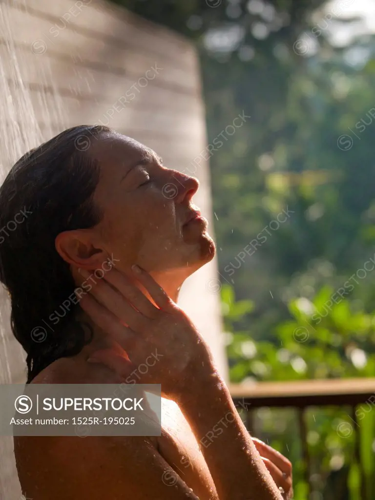 Side view of a woman taking an outdoor shower in Bali