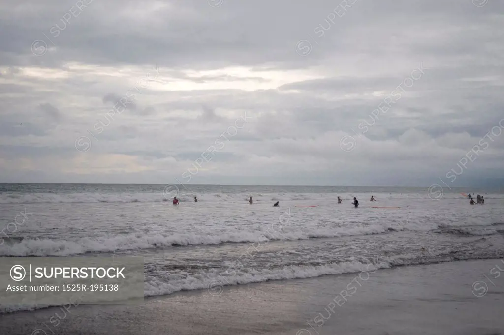 People swimming by the shoreline in Bali