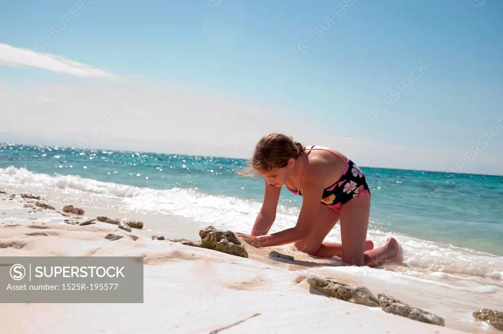 Young girl playing in the sand on Belizean Isle in Belize