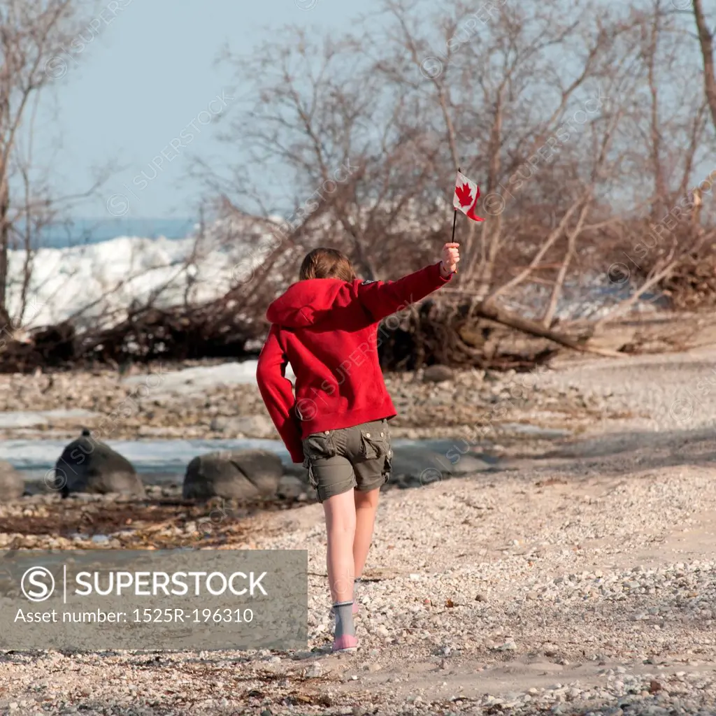 Girl running along Lake Winnipeg shoreline in Gimli, Manitoba Canada