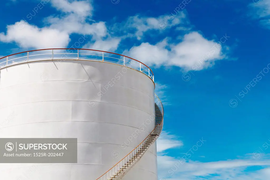 Industrial fuel tank against blue sky background