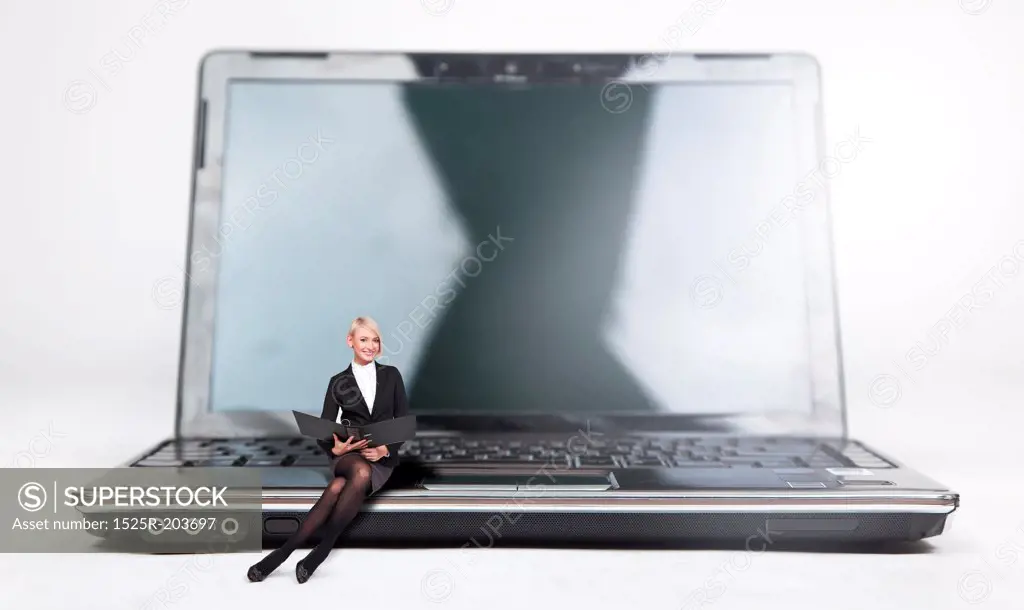 Young businesswoman sitting on a laptop, isolated on white
