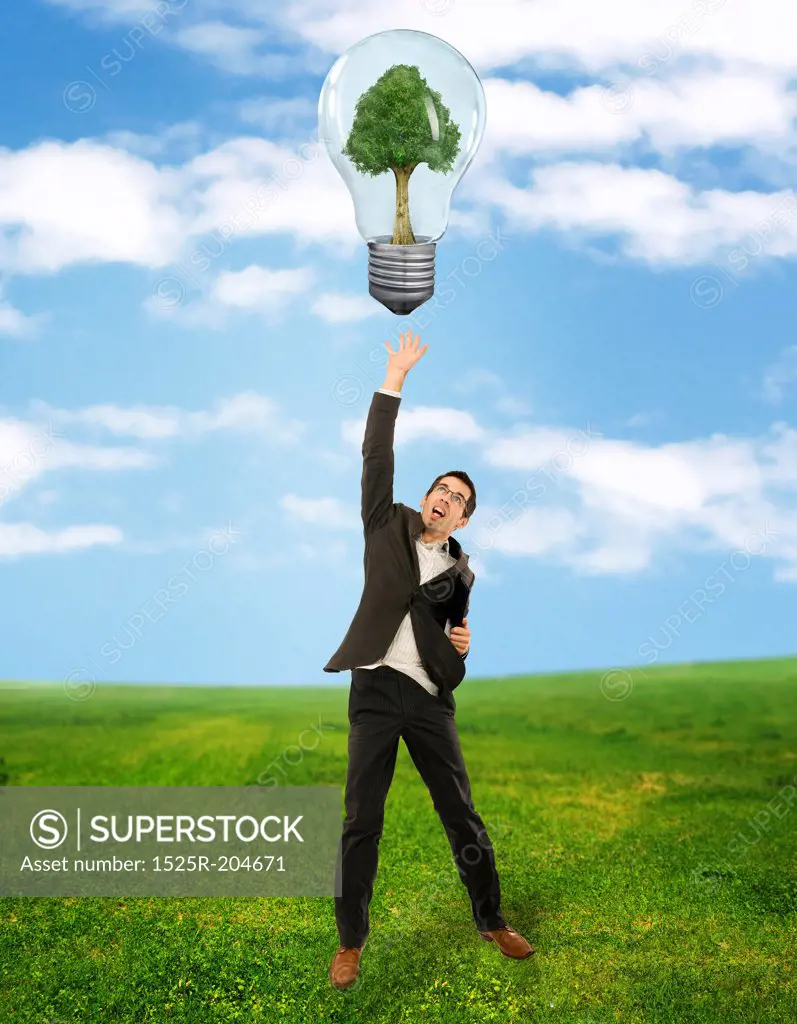 Businessman reaching green energy symbol
