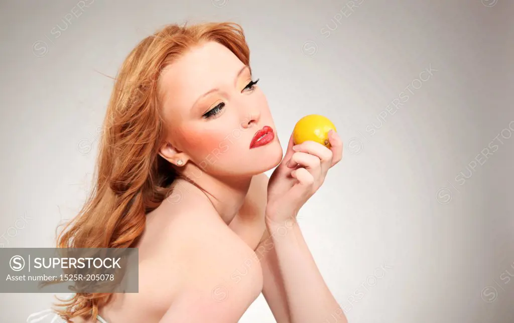 Young attractive woman holding a lemon