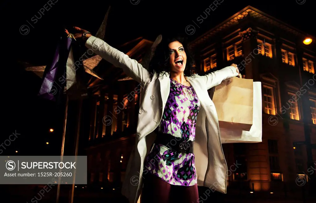 Elegant lady holding shopping bags, on the night
