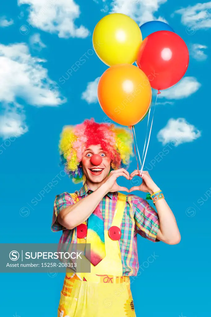 Portrait clown with balloons against the blue sky