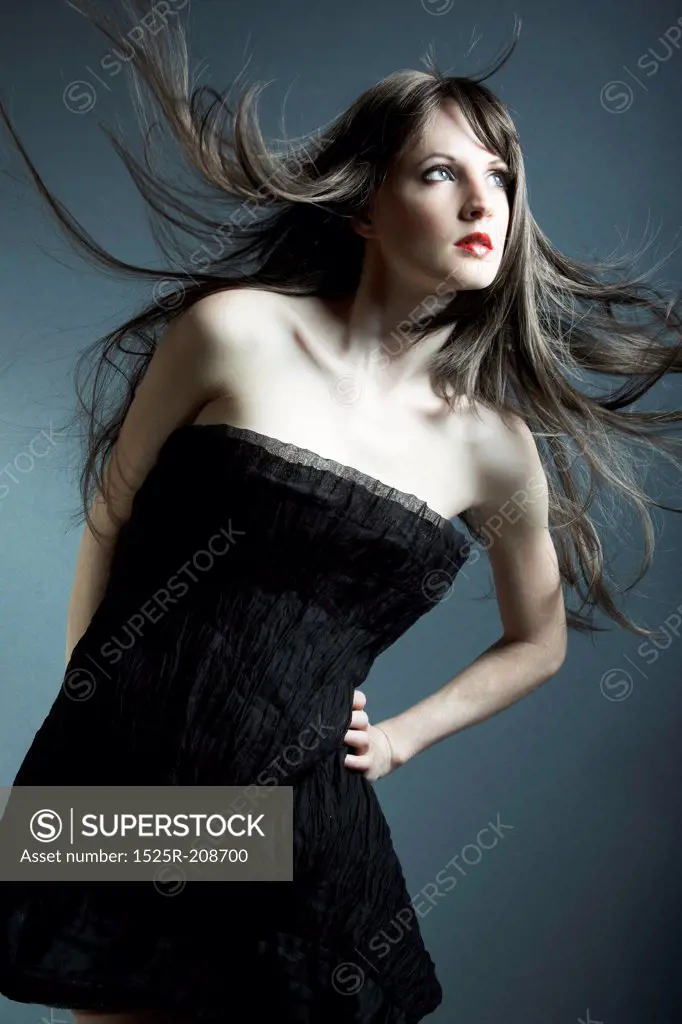 The young beautiful girl in black dress with developing hair