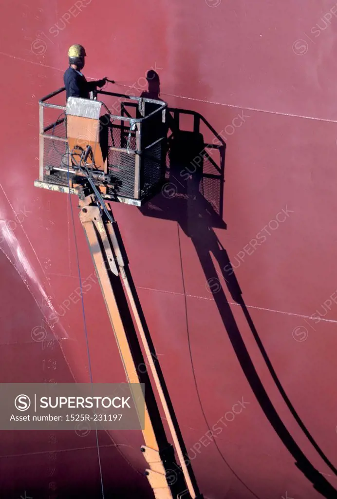 Worker Spray Painting Huge Boat