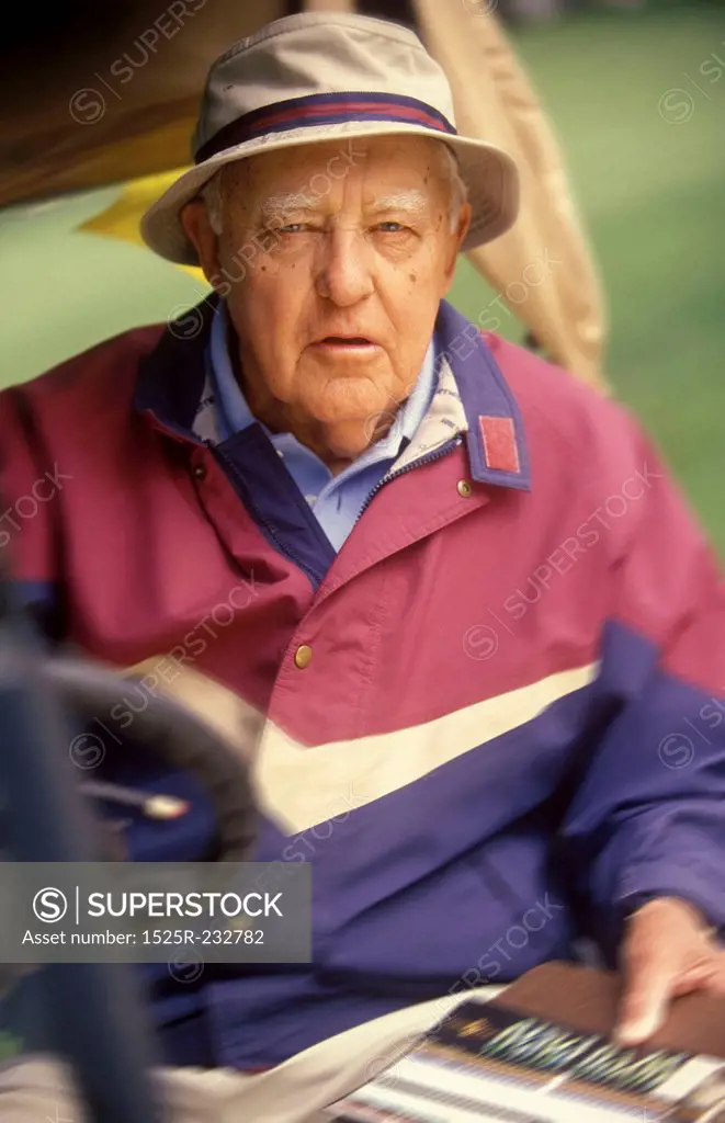 Elderly Male Golfer Driving Golf Cart