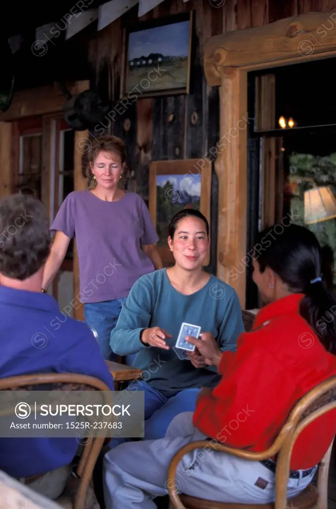 Friends Sitting In A Cabin Playing Cards
